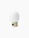An angled view of the JWDA Portable Table Lamp in Alabaster White, with its cylindrical base, black dimmer and frosted shade.
