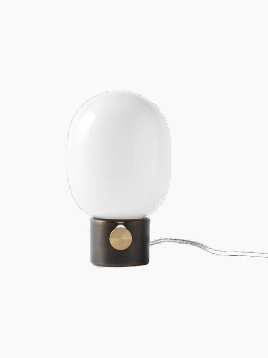 A front view of the JWDA Table Lamp, Small, with a bronzed brass base, a brass dimmer, and a large white opal glass shade.