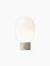 JWDA Table Lamp, Small, with a light grey concrete base, circular brass dimmer, and an illuminated opal glass shade.