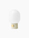 Angled view of the JWDA Table Lamp, Small, in Alabaster White steel with a brass dimmer and a rounded opal glass shade.