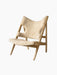 An angled view of the Knitting Lounge Chair, featuring a natural oak frame and upholstered in fluffy Nature sheepskin.