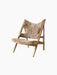 Angled view of the Knitting Lounge Chair, featuring Sahara sheepskin upholstery with elbow cut-outs and a natural oak frame.