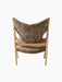 Back view of the Knitting Lounge Chair, showcasing its light brown Sahara sheepskin upholstery and natural oak wooden frame.