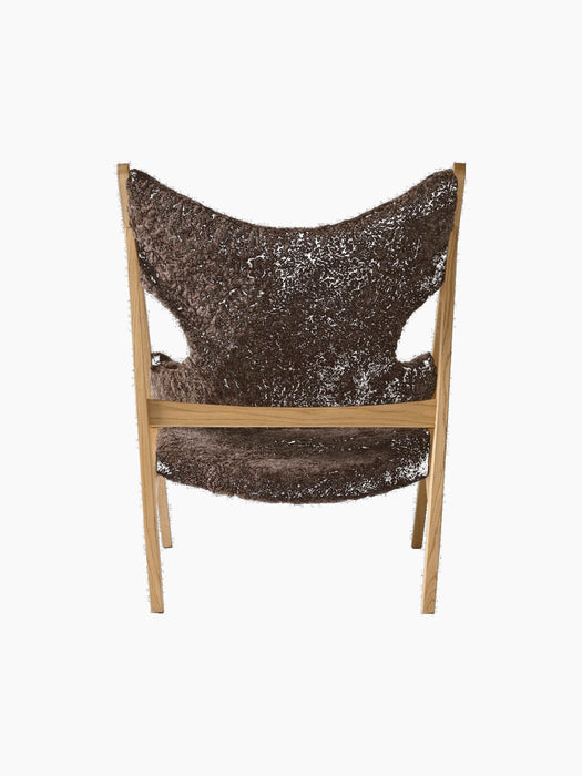 Back view of the Knitting Lounge Chair in dark brown Sheepskin Root, showing distinct elbow cut-outs and natural oak frame.