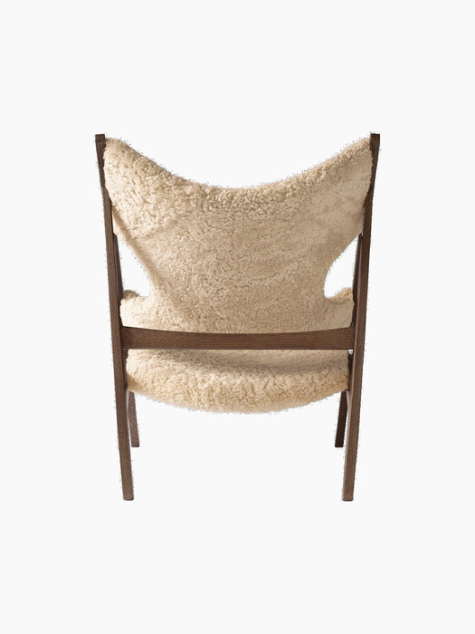 Back view of the Knitting Lounge Chair in dark stained oak and natural sheepskin, showing the distinctive elbow cut-outs.