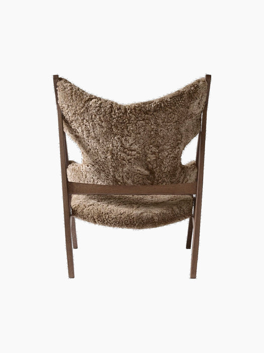 Back view of the Knitting Lounge Chair in Sahara sheepskin, featuring a dark stained oak frame and characteristic cut-outs.