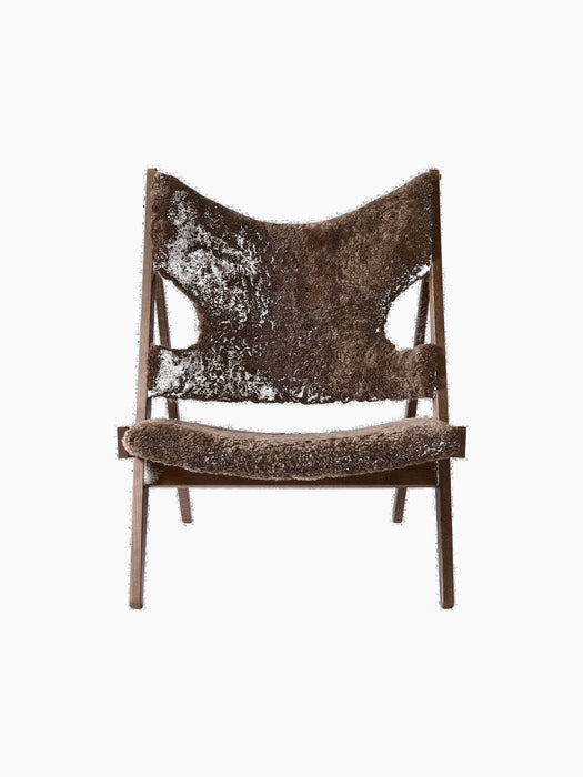 A front view of the Knitting Lounge Chair with a dark stained oak frame and plush, dark brown sheepskin upholstery.