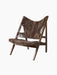 An angled view of the Knitting Lounge Chair, showing its dark stained oak frame and warm brown sheepskin seat and back.