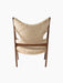 A back view of the Knitting Lounge Chair, natural sheepskin upholstery on a dark walnut frame with side cut-outs.