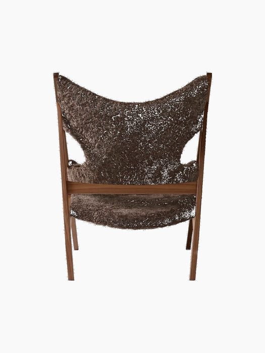 The back of the Knitting Lounge Chair, with a walnut wood frame and dark brown Root sheepskin upholstery with cut-outs.