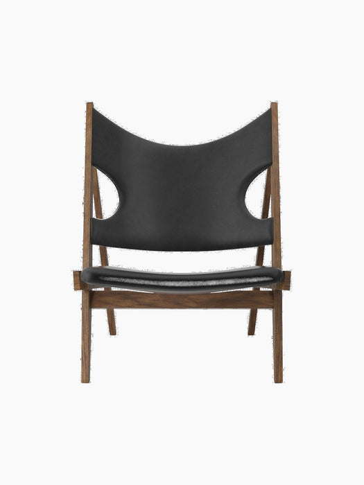Knitting Lounge Chair shown from the front, with a walnut frame and black leather featuring signature cut-outs.