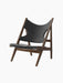 The Knitting Lounge Chair, shown at an angle, features a dark walnut frame and black Dakar leather seat with elbow cut-outs.