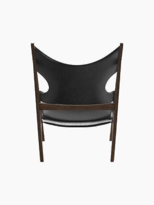 Back view of the Knitting Lounge Chair, showing its dark walnut frame and black leather seat with distinctive side cutouts.