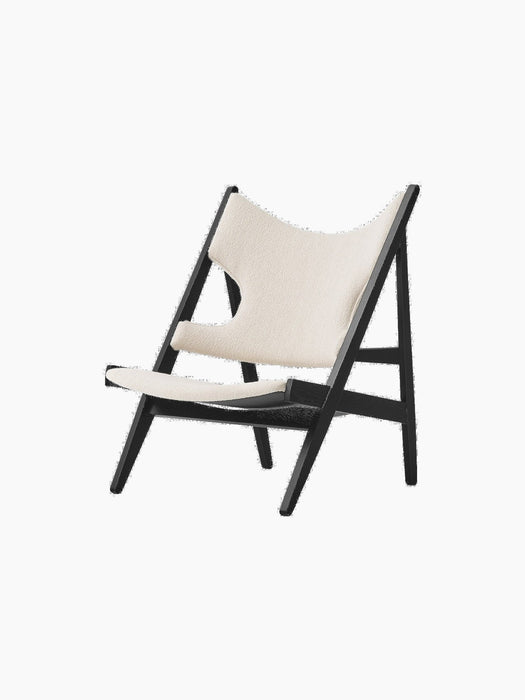 Angled view of the Knitting Lounge Chair in Black Oak, featuring an ivory bouclé seat and backrest on a black oak frame.