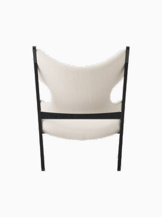 Rear view of the Knitting Lounge Chair in black oak with ivory bouclé upholstery, showing the distinctive cutouts.