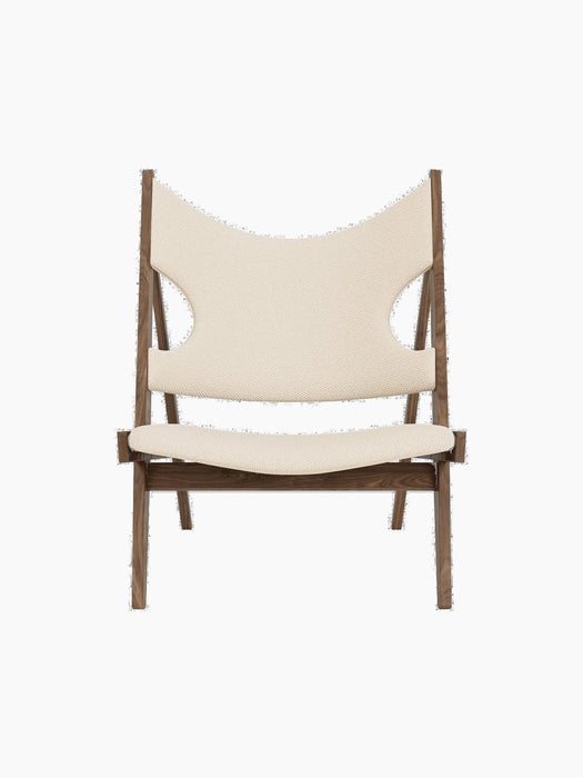 A front view of the Knitting Lounge Chair, with a dark wood frame and off-white textile seat and back with elbow cut-outs.