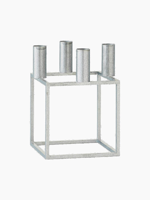 The Kubus 4 candle holder in textured zinc finish. It features a geometric, cube-shaped frame with four cylindrical holders.