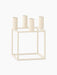 An ivory-coloured Kubus 4 candle holder with a geometric, square frame and four candle sockets, shown from an angle.