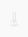 A white Kubus Line candle holder with two lit candles sitting atop the matching Kubus Base, shown against a black background.