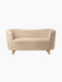Front view of the Mingle Sofa in honey sheepskin. The compact two-seater has curved arms and rests on four natural oak legs.