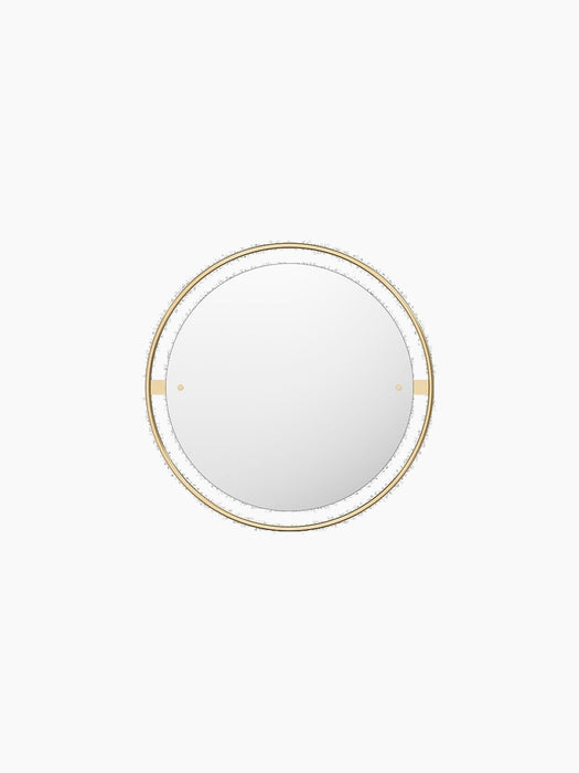 Front view of the Nimbus Mirror 60. The round mirror is set within a black ring, surrounded by a larger polished brass frame.