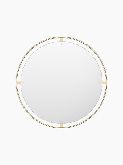 A front view of the large, circular Nimbus Mirror 110. It features a distinctive halo-like frame crafted from polished brass.
