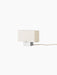 Angled side view of the Nonna Table Lamp, showing its rectangular sand-coloured textile shade and brushed aluminium base.