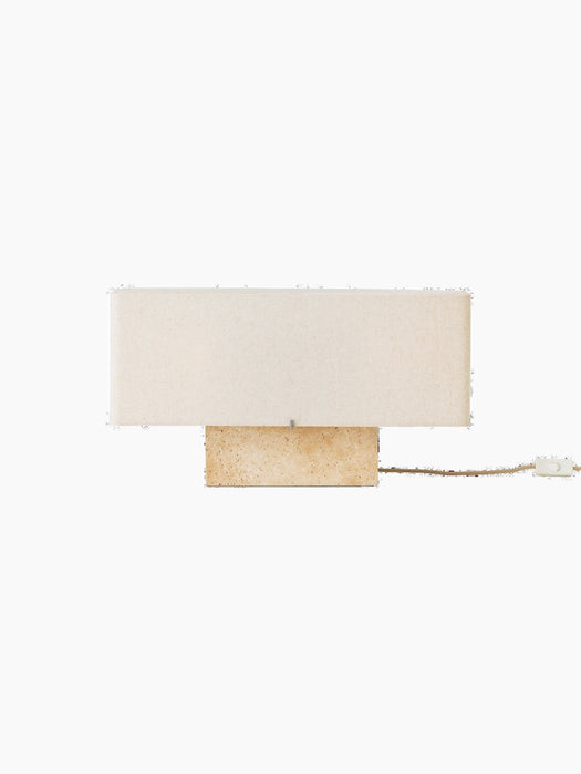 Front view of the Nonna Table Lamp with a rectangular travertine base and a wide, sand-coloured linen lampshade.
