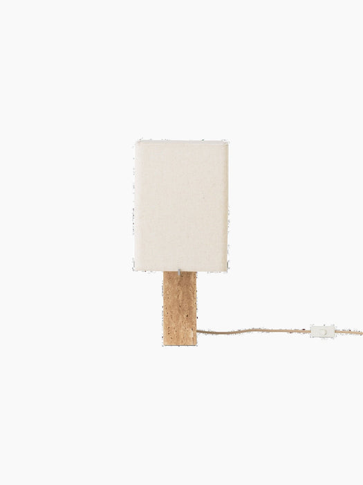Front view of the switched-off Nonna Table Lamp, showing its rectangular travertine base and sand-coloured linen shade.