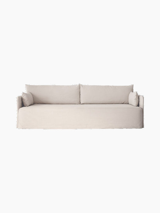 Front view of the Offset Sofa w. Loose Cover, a three-seater in a light-coloured fabric, displayed on a black background.
