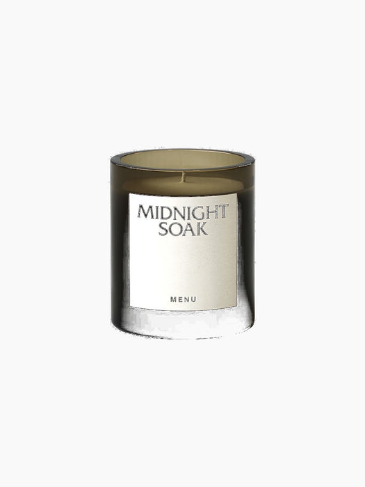 A close-up of the Olfacte Scented Candle in 'Midnight Soak'. The candle is poured into a dark glass jar with a white label.