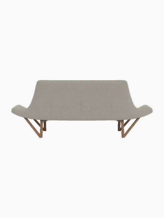 Back view of the Pagode Sofa in light grey Re-Wool upholstery with a walnut frame and V-shaped legs on a black background.