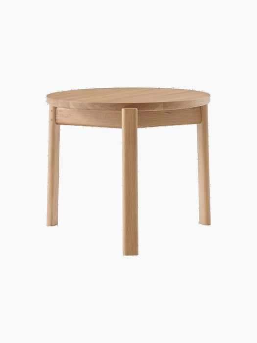 Front view of the Passage Lounge Table in natural oak. The table features a round top and three solid, straight wooden legs.