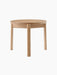 Front view of the Passage Lounge Table in natural oak. The table features a round top and three solid, straight wooden legs.