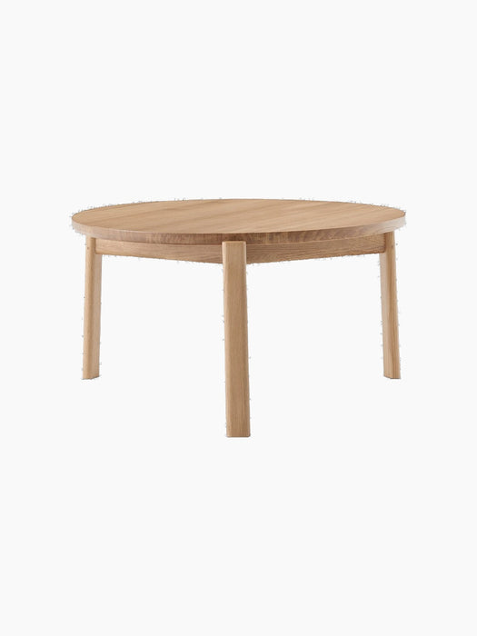 A front-facing image of the round Passage Lounge Table in natural oak, showcasing its circular top and four solid wood legs.