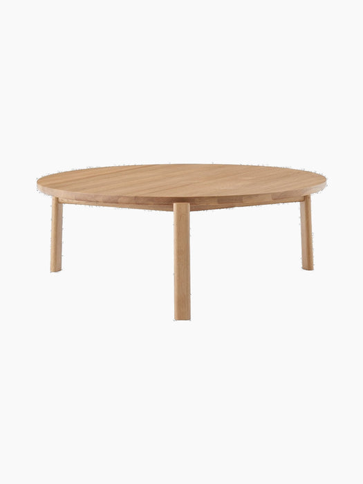 Front view of the Passage Lounge Table in natural oak. The low, round table has a solid wood top and three sturdy legs.
