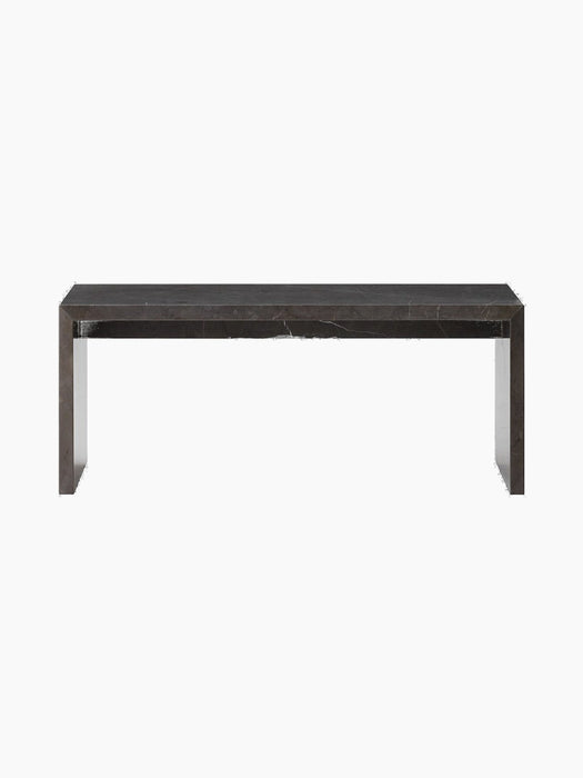 Front-on view of the Plinth Bridge, a long, low coffee table made from dark grey Kendzo marble with distinctive white veins.