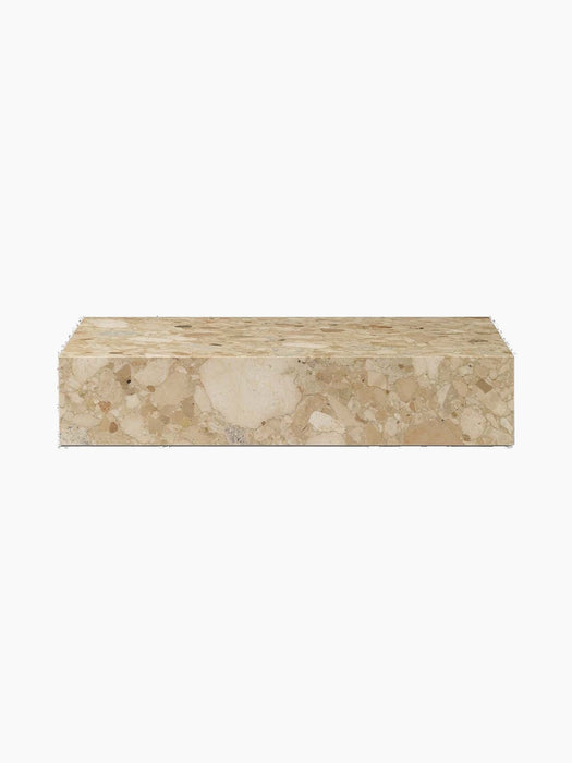 A front view of the Plinth Low, a rectangular podium crafted from textural Kunis Breccia stone with beige and cream tones.