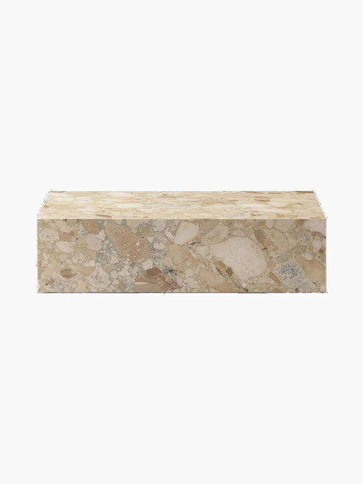 Front view of the Plinth Low, a rectangular podium in textural Kunis Breccia stone with beige and grey patterns.