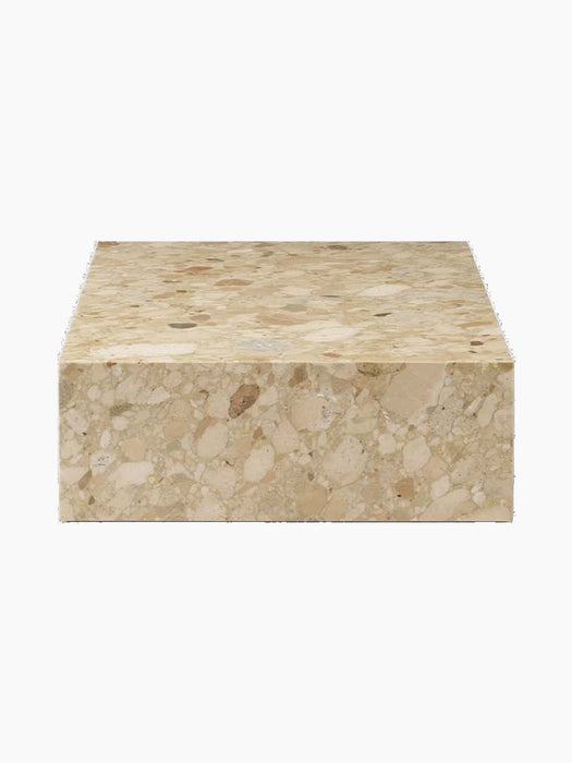 A side view of the Plinth Low table, crafted from beige and brown patterned Kunis Breccia stone against a black backdrop.