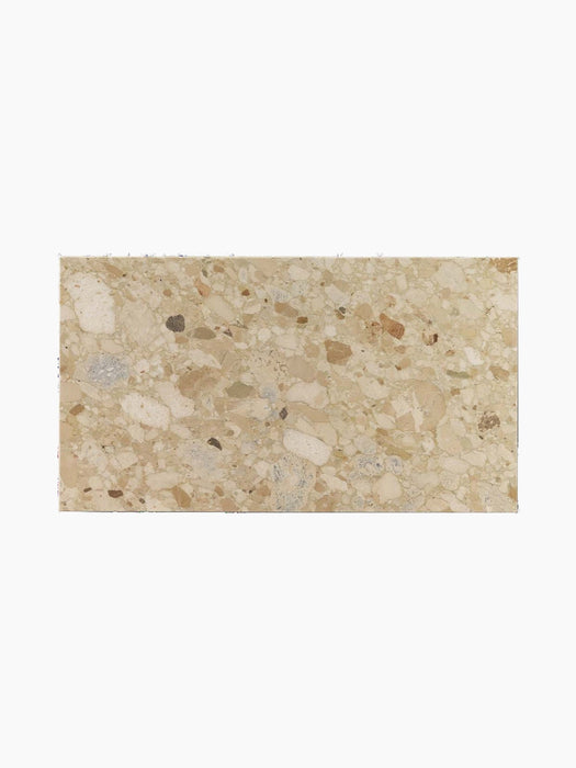 A top-down detailed view of the Kunis Breccia stone top for the Plinth Low table, showing its composite, multi-toned texture.