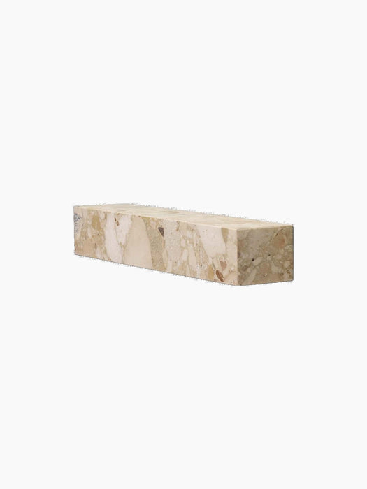 A Plinth Shelf in Kunis Breccia marble, a rectangular block of beige and cream stone with brown fragments, shown at an angle.