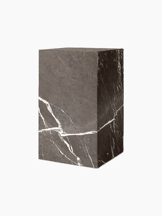 The Plinth Tall in Brown-Grey Marble, a rectangular pedestal at an angle, featuring bold white veining on a dark surface.