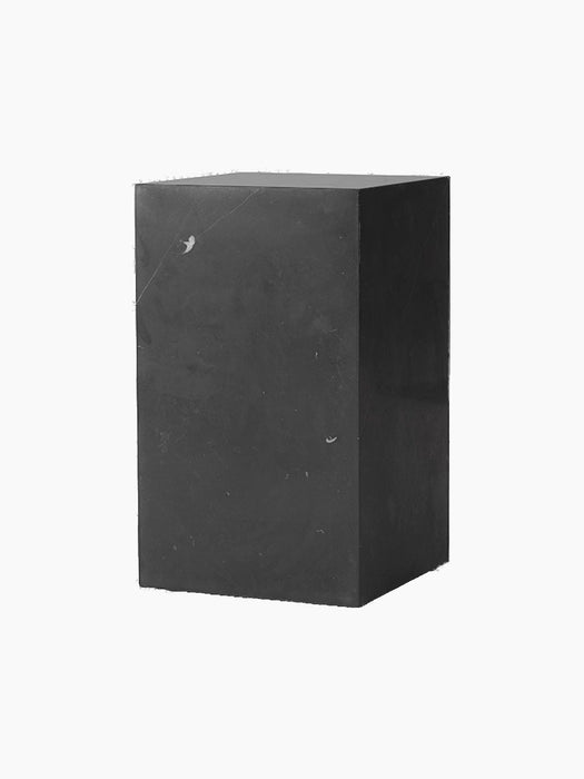 A tall, rectangular Plinth in black marble with subtle white veining, shown at an angle against a stark black background.