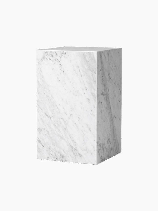 A tall, rectangular Plinth in white marble with soft grey veining, shown from an angled perspective on a black background.