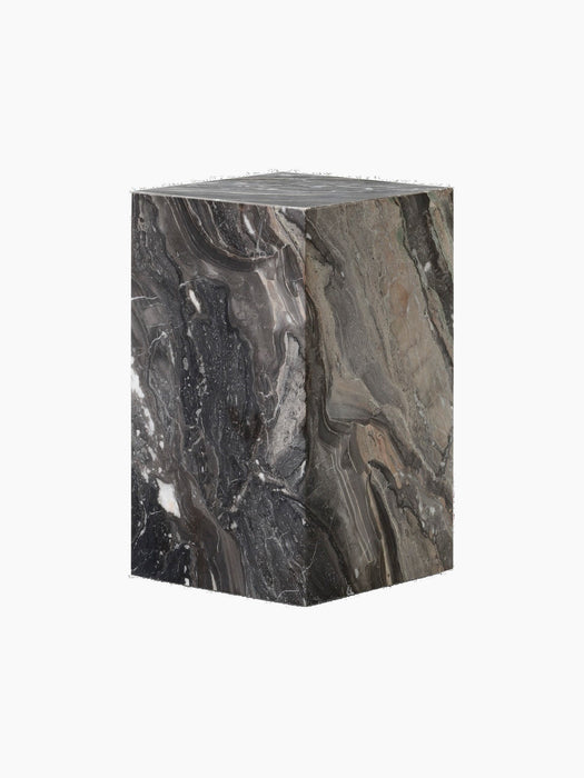 Angle view of the Plinth, a cuboid table in dark marble with swirling grey, white, and beige veins on a black background.