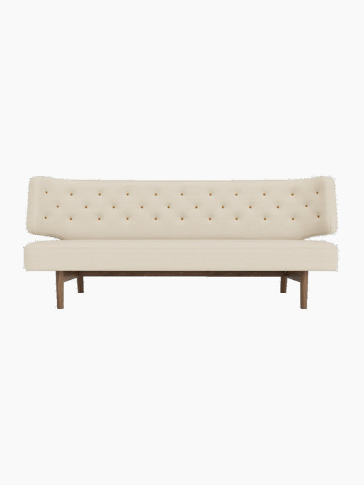 Front view of the Radiohus Sofa P2 in light fabric upholstery, with a quilted back with brown buttons and a walnut frame.