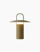 A front view of the illuminated Ray Table Lamp, Portable, in a matte dusty green finish, set against a black background.