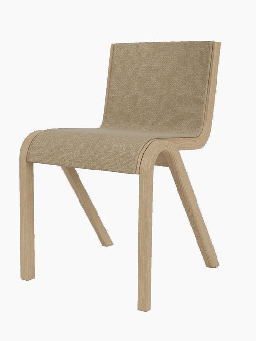 Three-quarter view of the Ready Dining Chair with a natural oak frame and front upholstered in beige bouclé fabric.