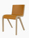 An angled view of the Ready Dining Chair, Front Upholstered, with a natural oak frame and a cantilevered seat in tan leather.